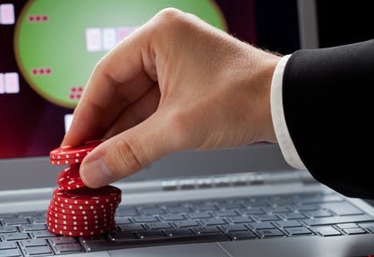 Player placing chips on a laptop which shows an online casino
